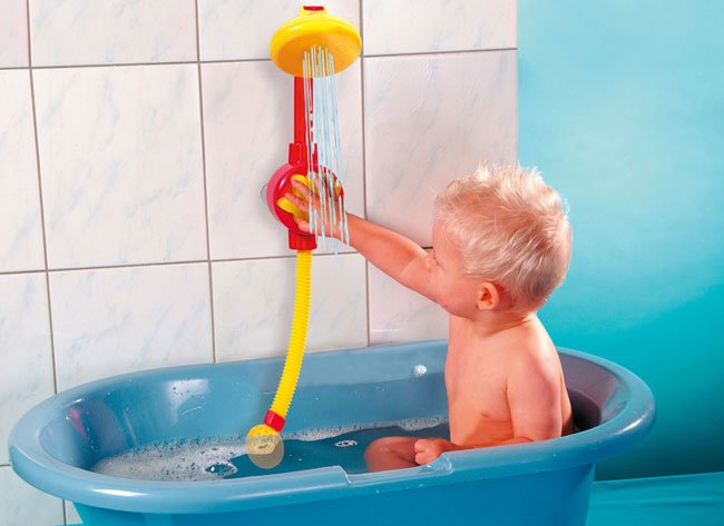 мальчик играет игрушкой в ванной