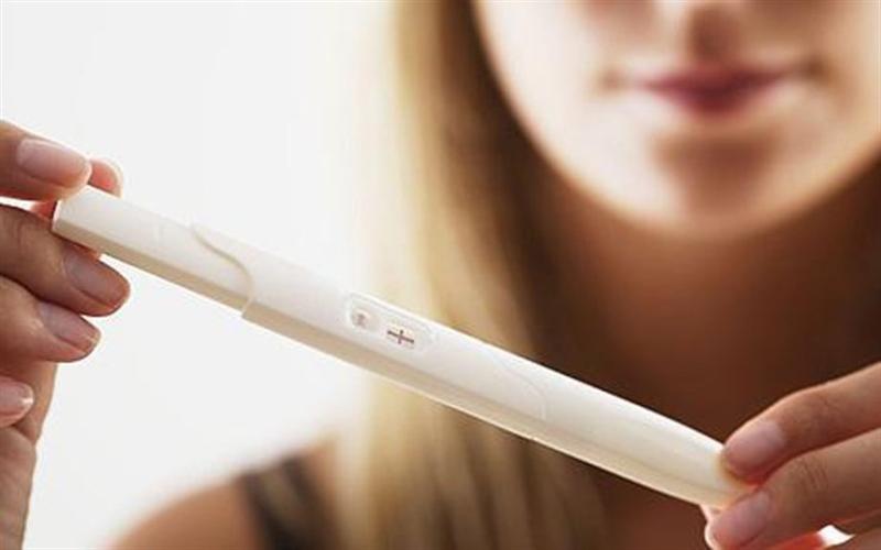 девушка смотрит результат теста на овуляцию