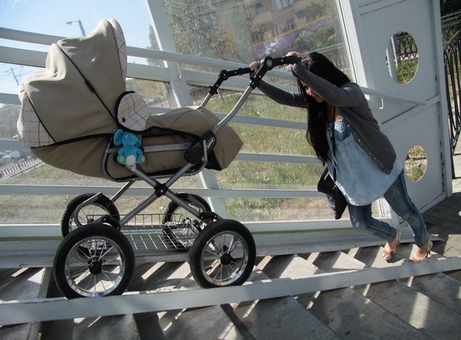 Мама катит коляску-люльку по пандусу
