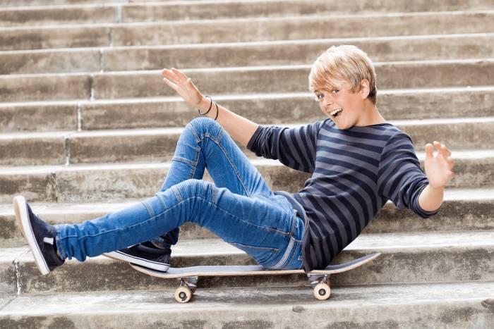 Парень сидит на ступеньках на скейте