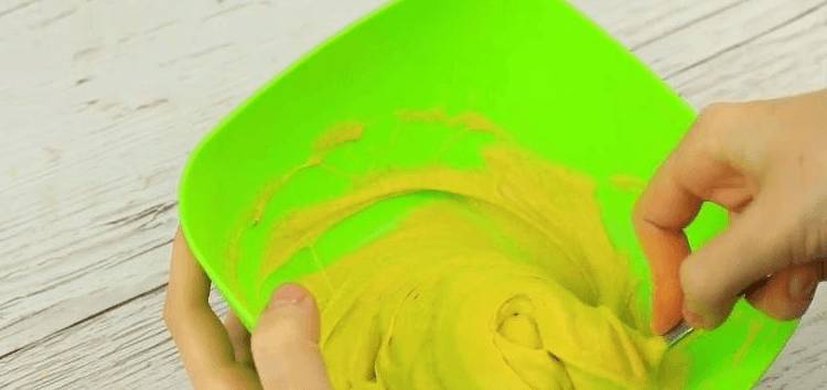 Руки ложкой вымешивают смесь в тарелке