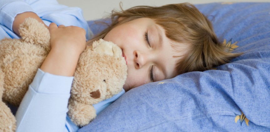 Ребёнок спит в обнимку с плюшевым мишкой