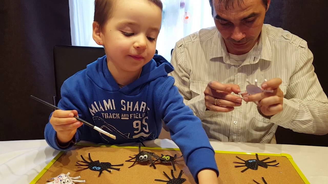 Папа с сыном делают поделку — бумажных паучков