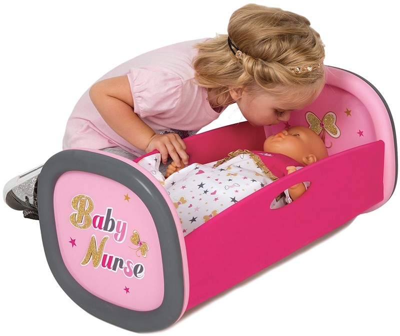 Девочка укладывает спать игрушечного грудного младенца