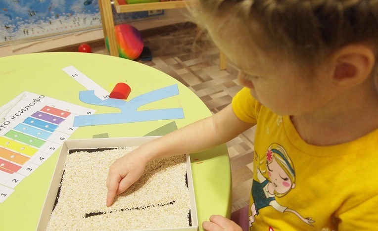 Девочка выводит букву на крупе