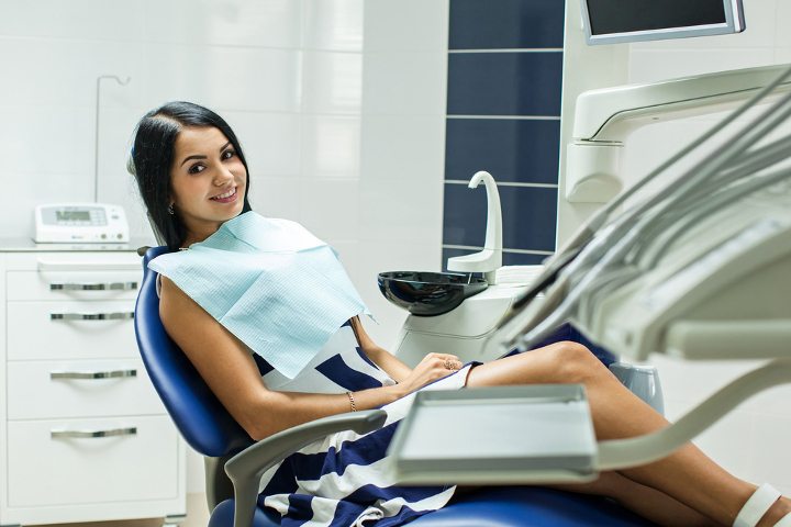 Женщина улыбается в кресле стоматолога