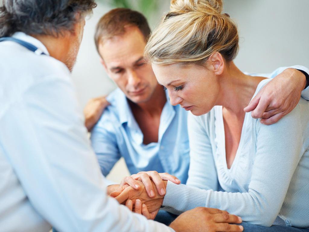 Доктор успокаивает женщину с мужем