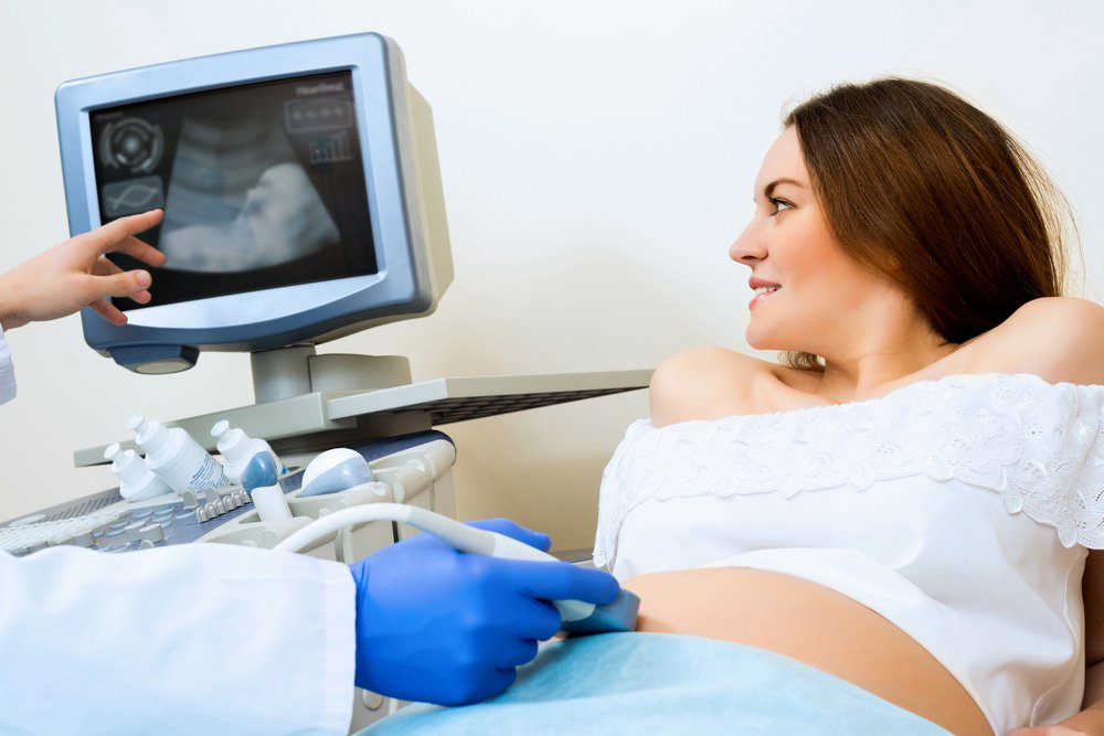 женщина лежит на кушетке и смотрит на монитор во время УЗИ