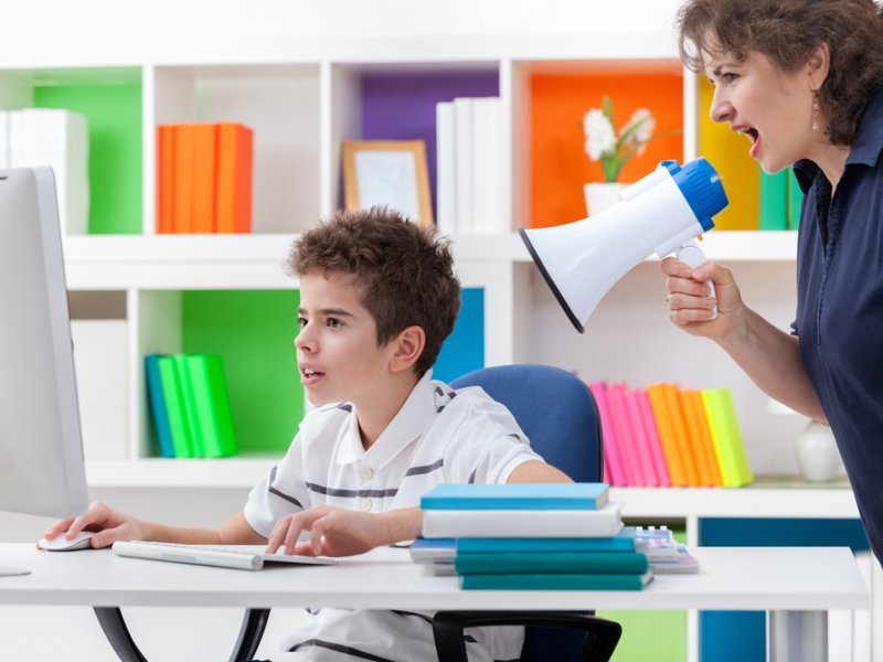 Мама кричит на сына, пока он сидит за компьютером