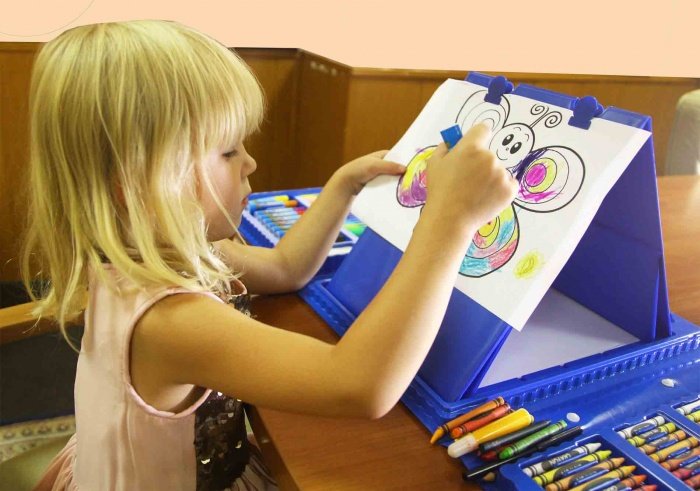 5. Девочка рисует на мольберте в наборе юного художника