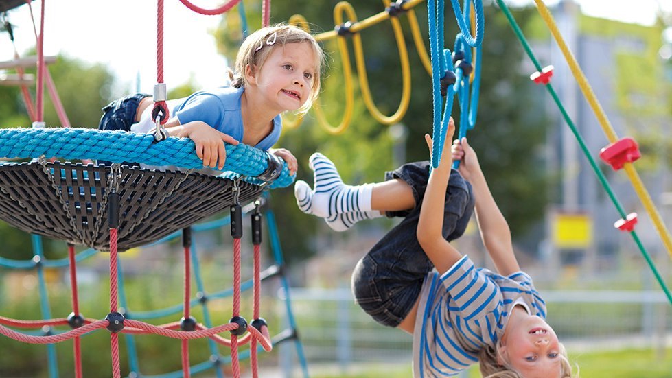 Девочка висит на кольце из каната вниз головой