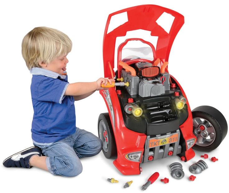 Мальчик чинит разобранную игрушечную машину