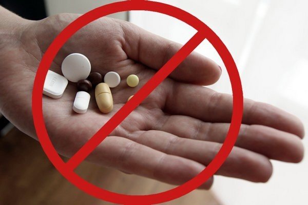 таблетки в ладони под знаком запрета