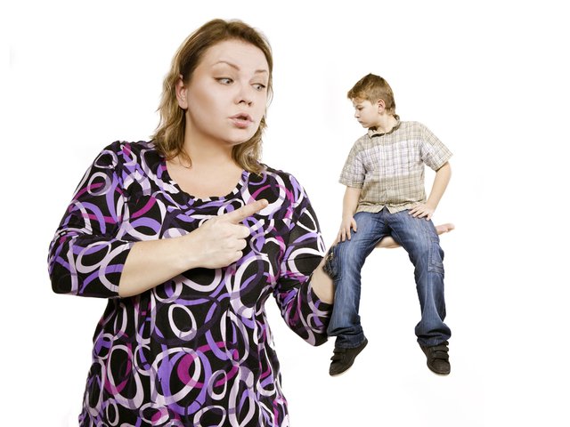 Мальчик сидит на руке у мамы, она грозит ему пальцем