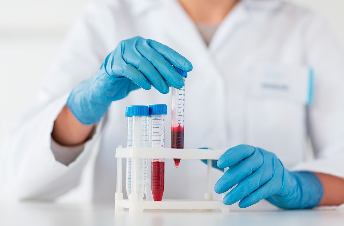 Лаборант берёт в руки пробирку с кровью