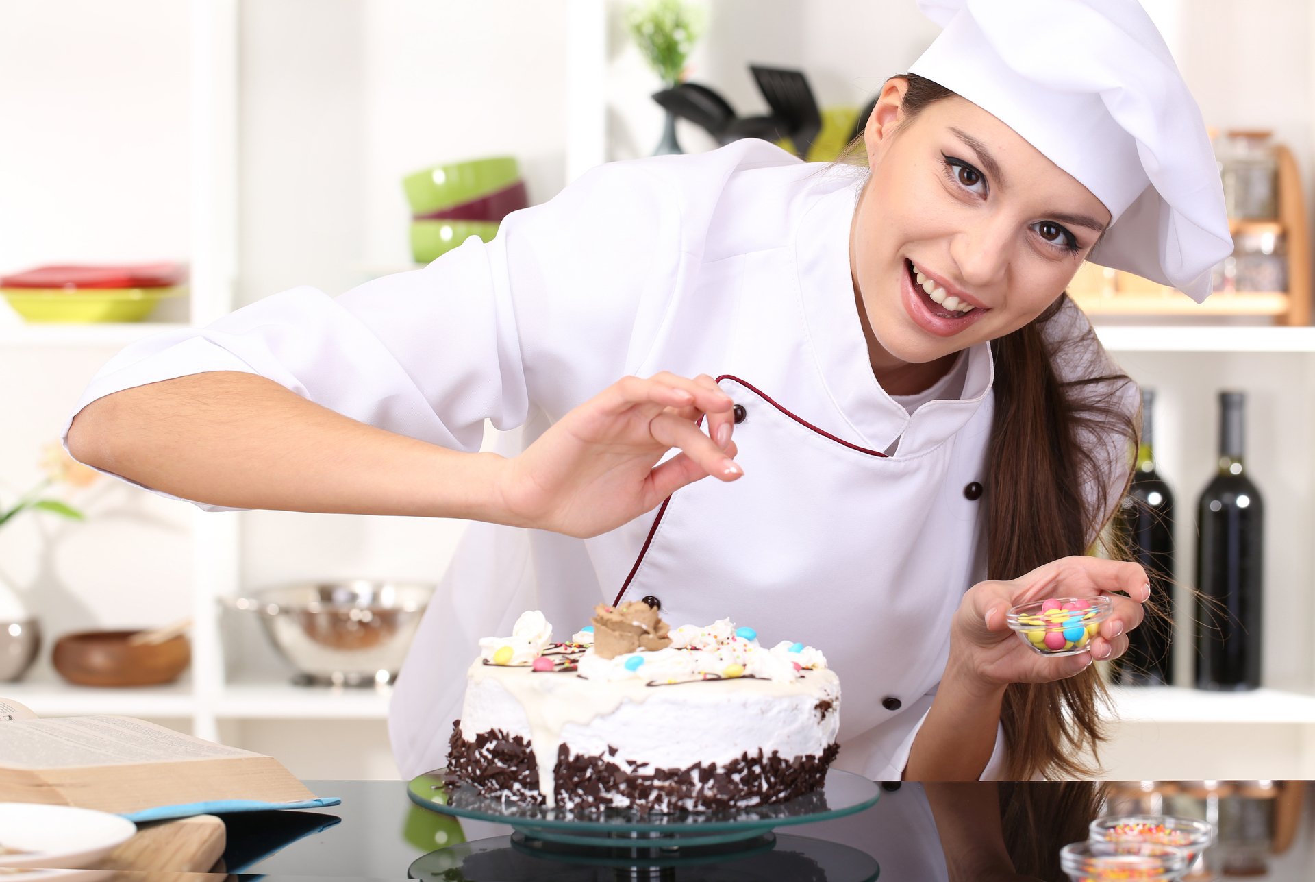 Девушка кондитер украшает торт
