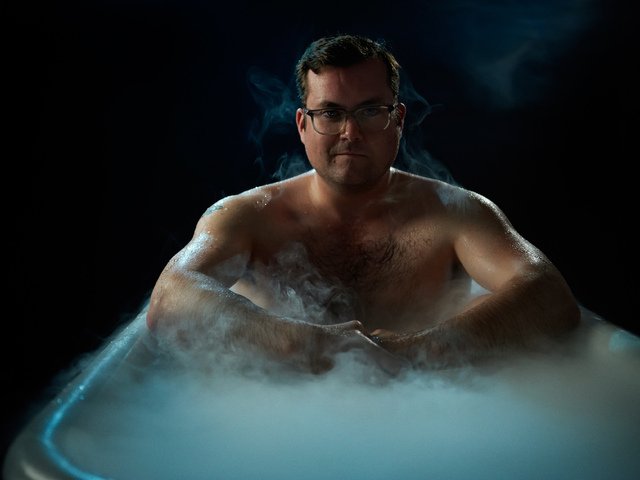 Мужчина сидит в ванне, от воды поднимается пар
