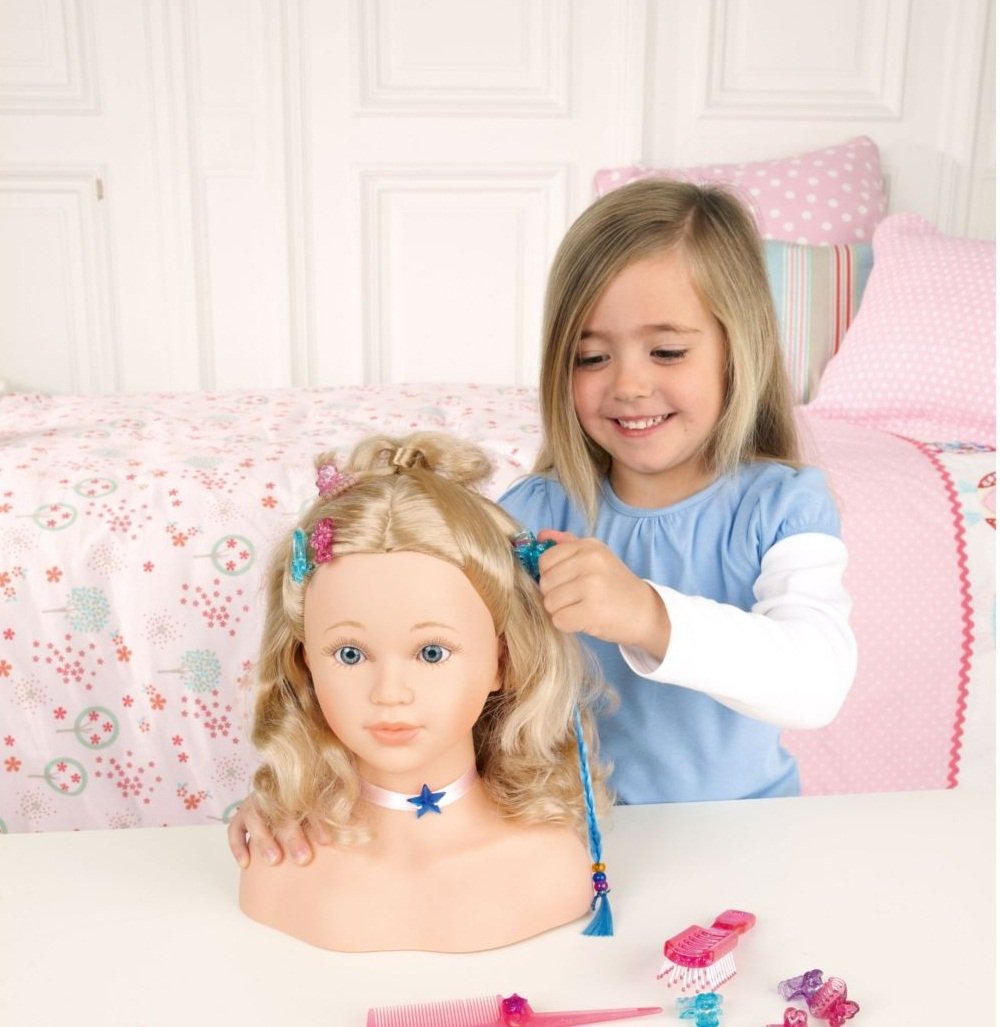 Девочка тренирует навыки парикмахера на манекене