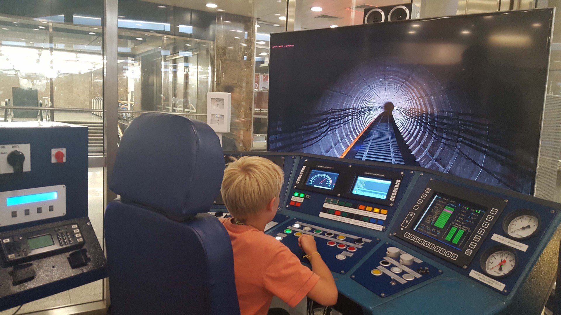 Мальчик сидит за тренажёром для машинистов метро