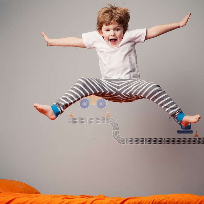 Мальчик скачет по кровати