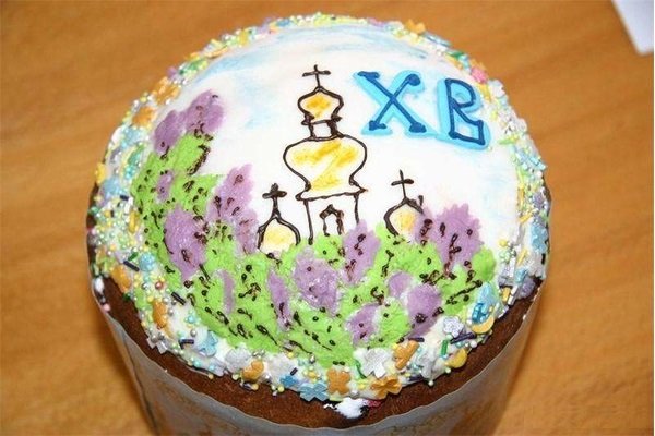 Пасхальный кулич с красиво расписанной глазурью (изображён храм на фоне природы)