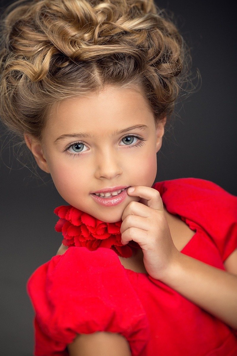 Девочка-модель позирует перед камерой