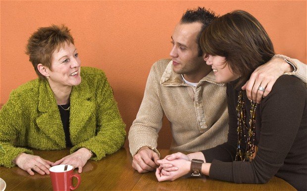 Тёща с улыбкой смотрит на молодую пару