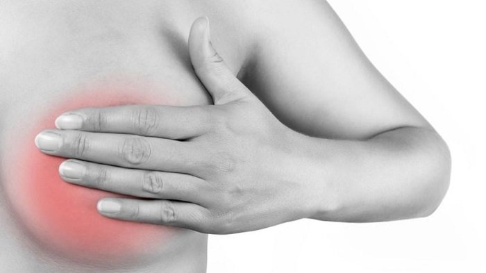 Женщина прикрывает рукой грудь, окрашенную в красный оттенок