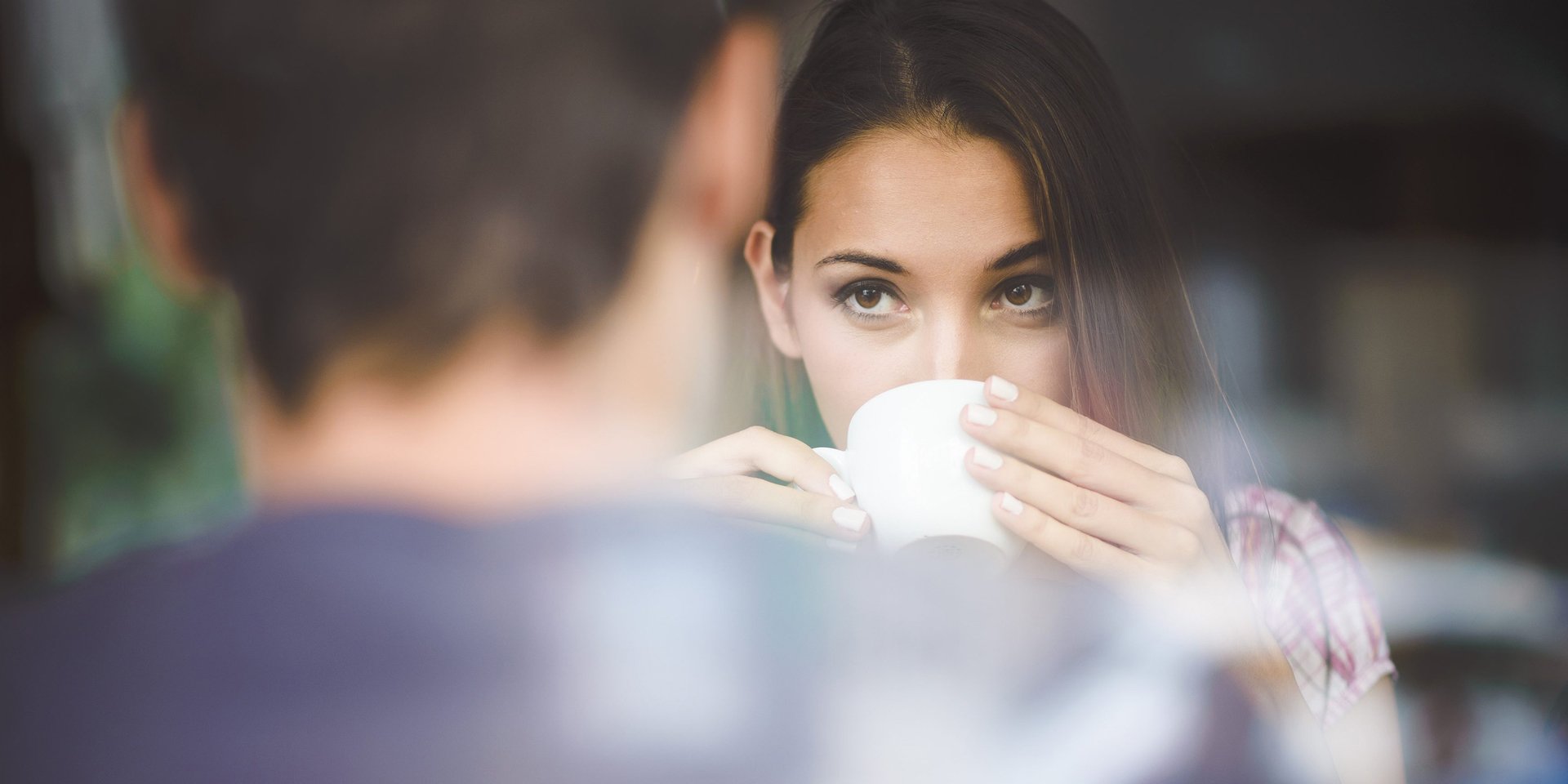 женщина пьет чай и смотрит на мужчину напротив