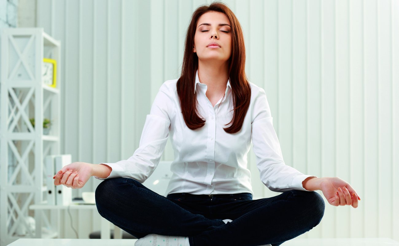Девушка медитирует в офисе
