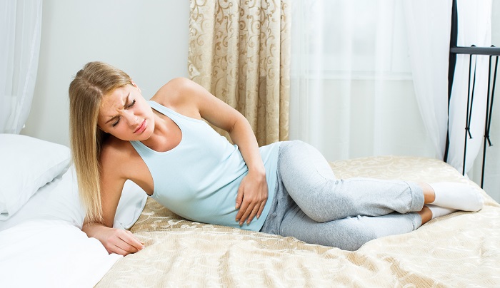 Женщина держится за низ живота