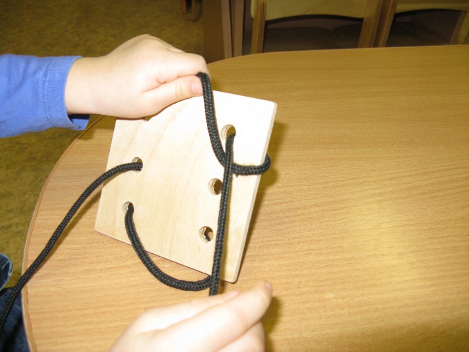 Ребёнок играет со шнуровкой