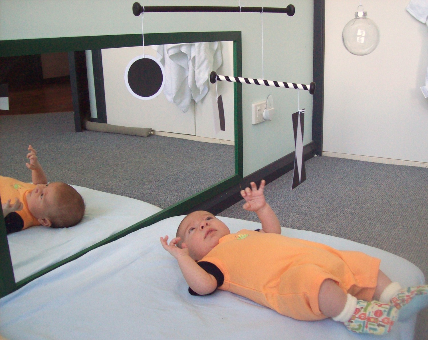 Ребёнок наблюдает за мобилем Мунари