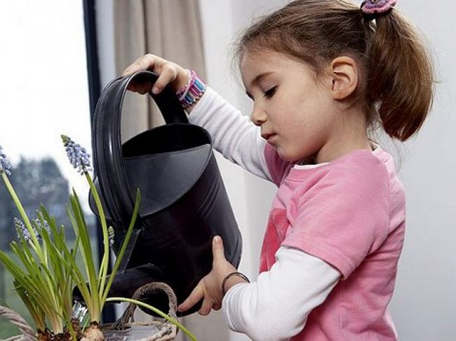 Девочка поливает цветы