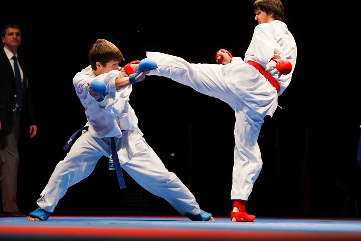 Соревнование по карате: один спортсмен наносит другому удар ногой в голову